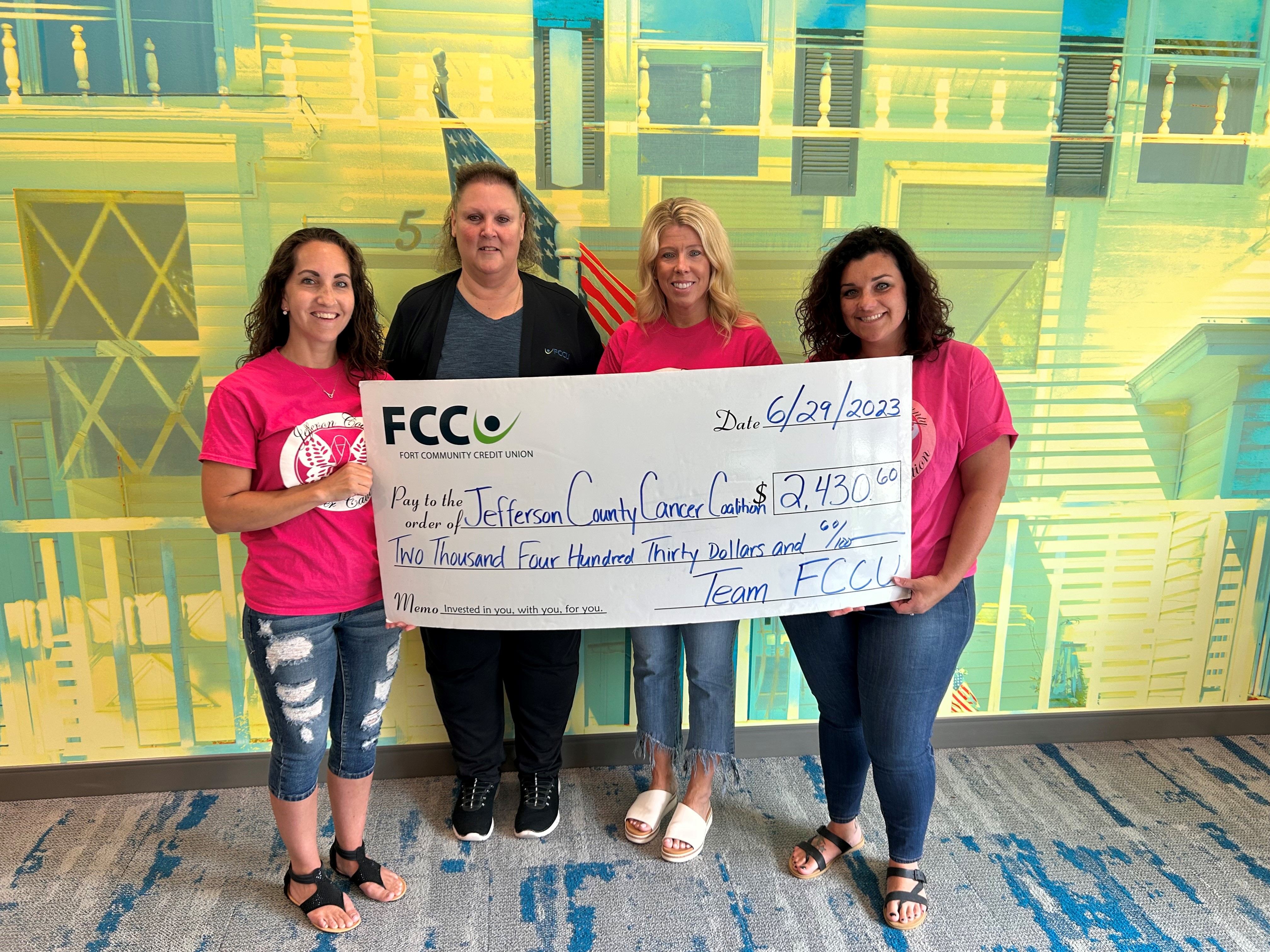 Photo of four women holding a giant check paid to the order of Jefferson County Cancer Coalition for $2430.60