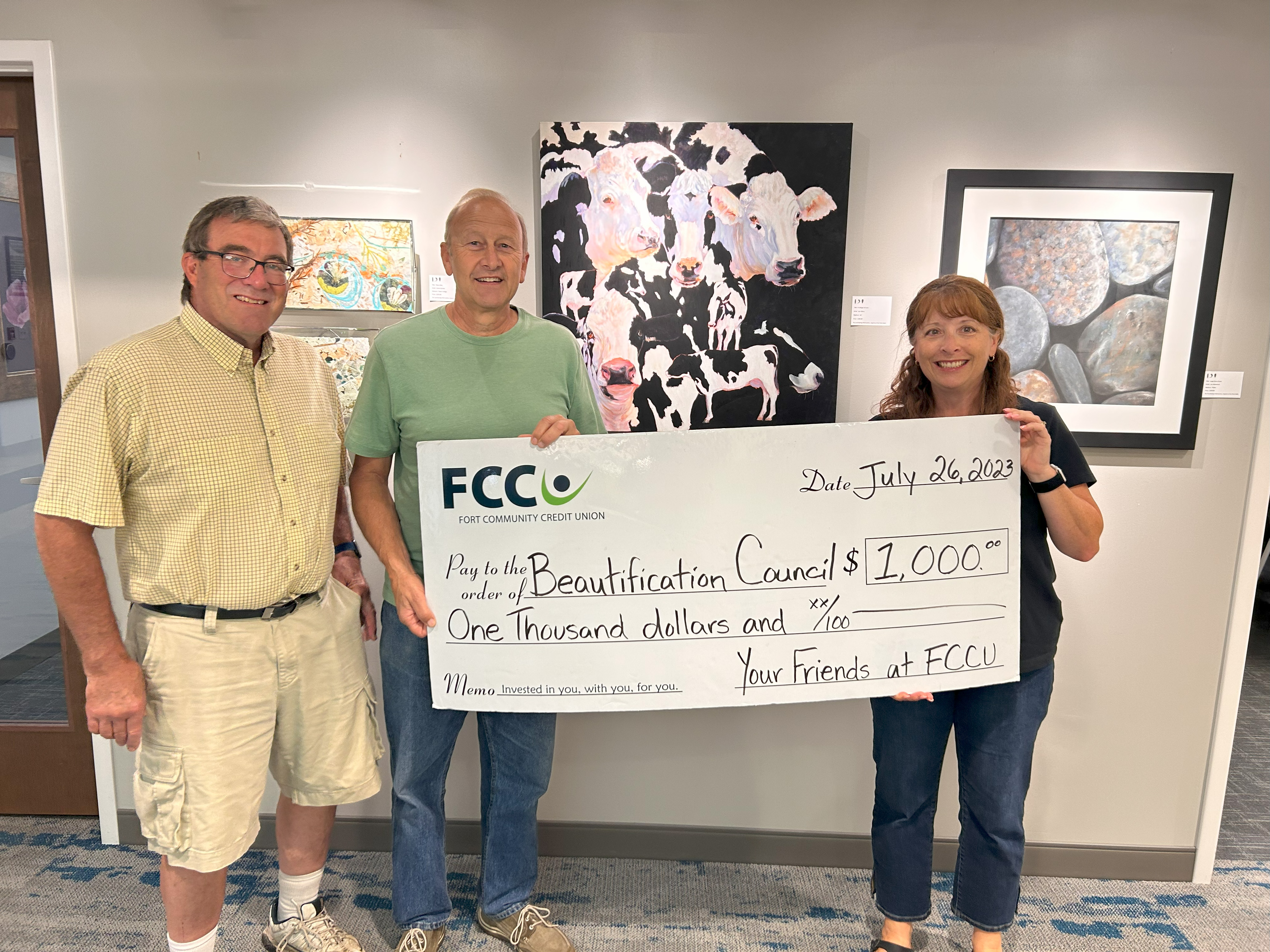 Photo of two men (Jude Hartwick, Alan Cook) and a woman (Sue Johnson) holding an oversized check for $1,000 written out to the Beautification Council from 'Your Friends at FCCU"